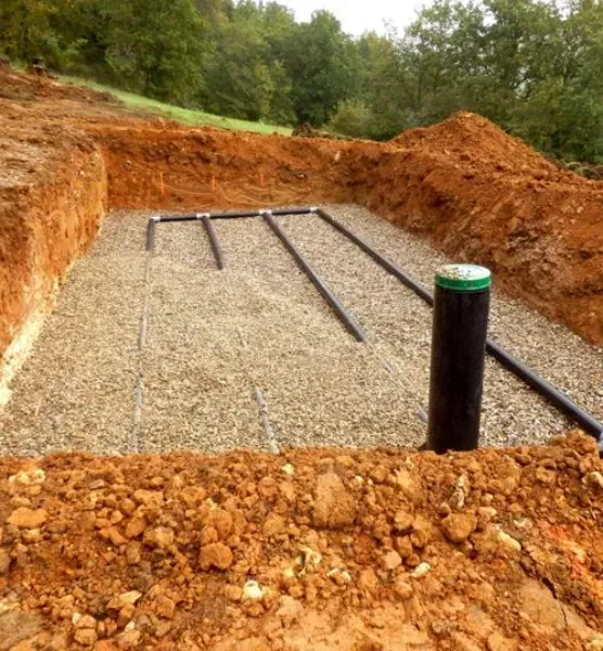 A pile of dirt with a black pipe in the middle of it.