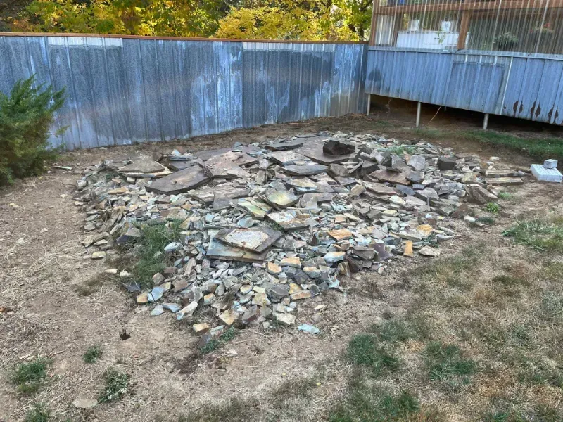 Concrete walkway and retaining walls under construction next to a house. Rebar visible.