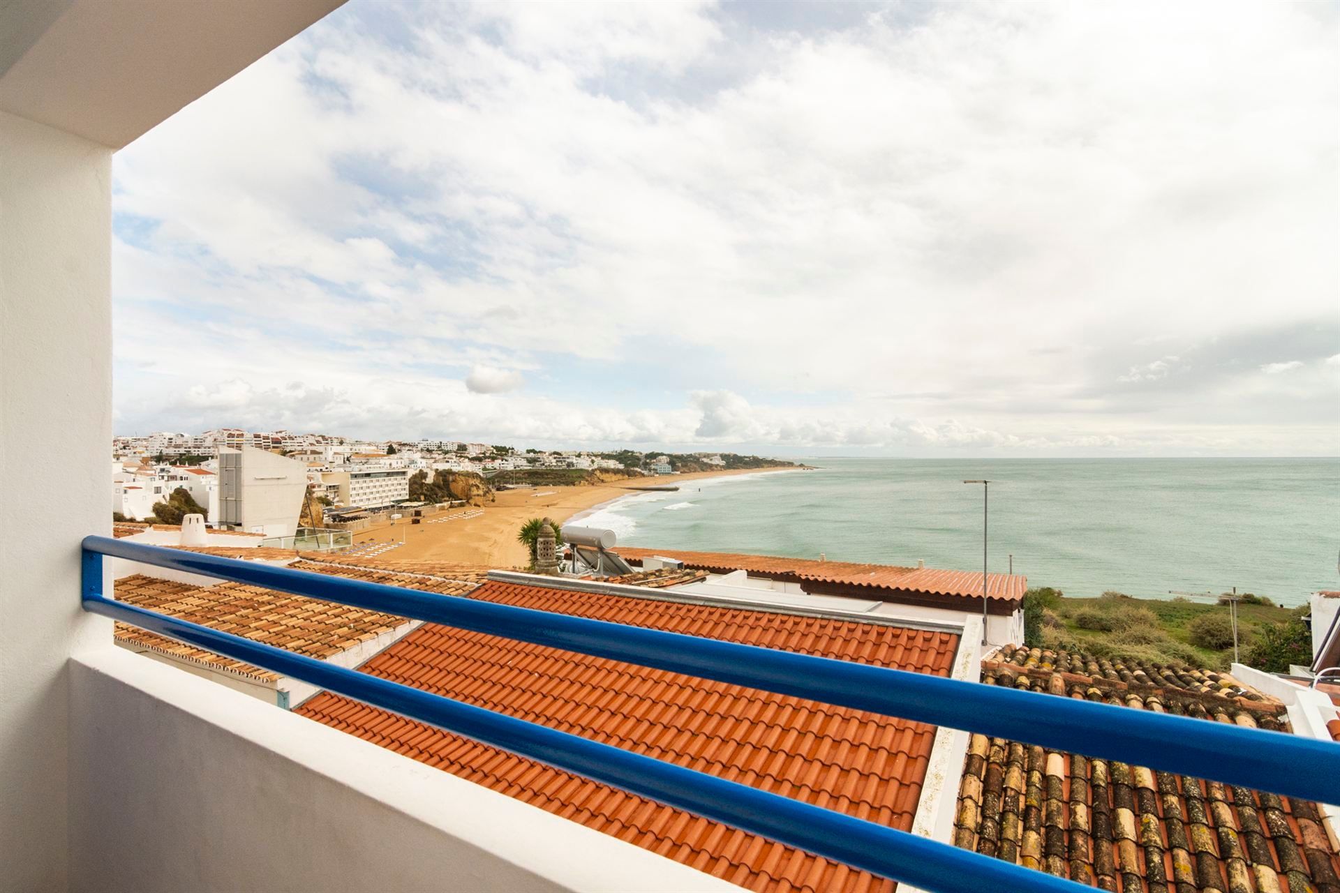 Uma varanda com vista para o oceano e para a cidade.