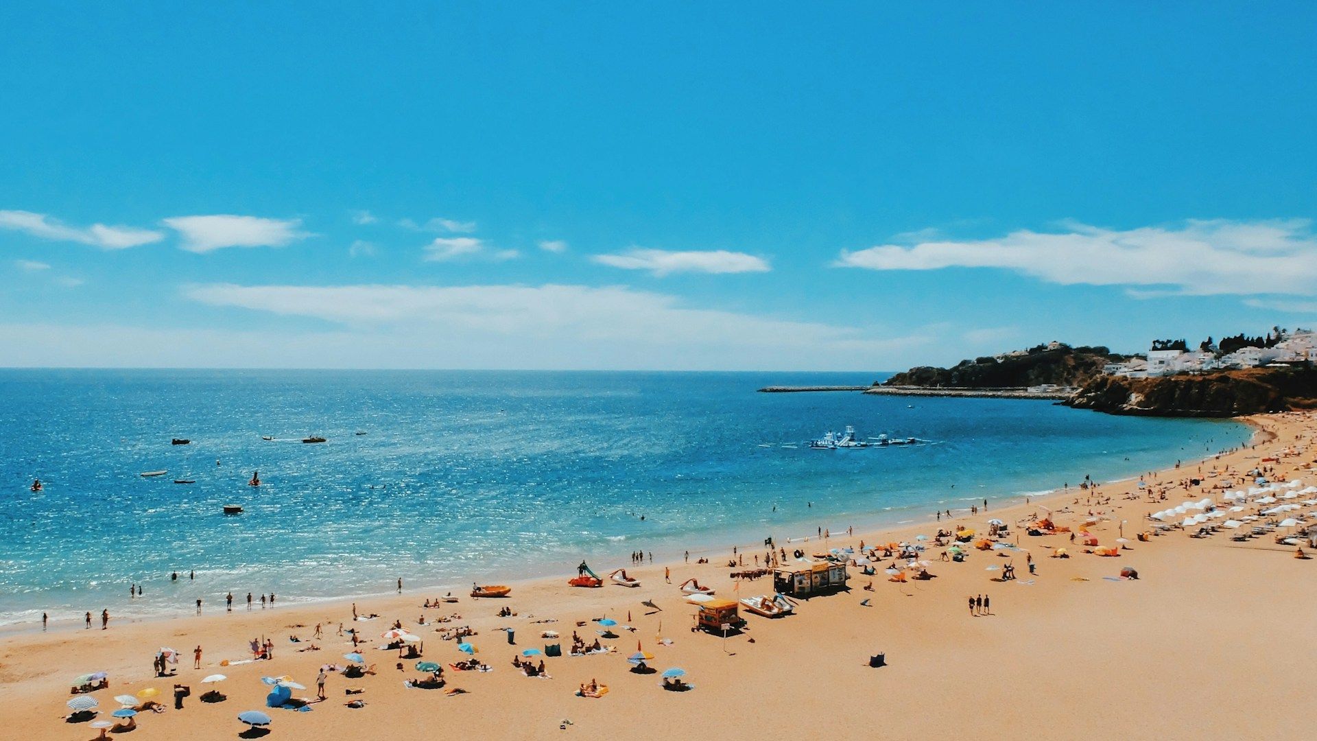 Uma praia cheia de pessoas e guarda-sóis em um dia ensolarado.