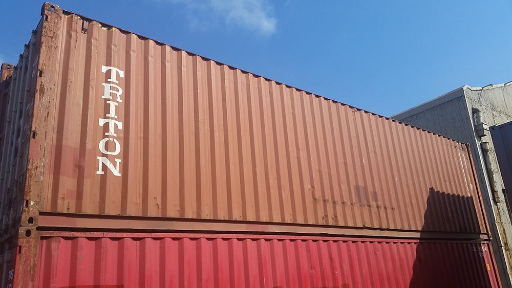 A Red Shipping Container With Triton Written on It — Oz Shipping Containers in Teralba, NSW