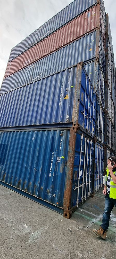 A Man is Standing in Front of a Stack of Shipping Containers — Oz Shipping Containers in Teralba, NSW