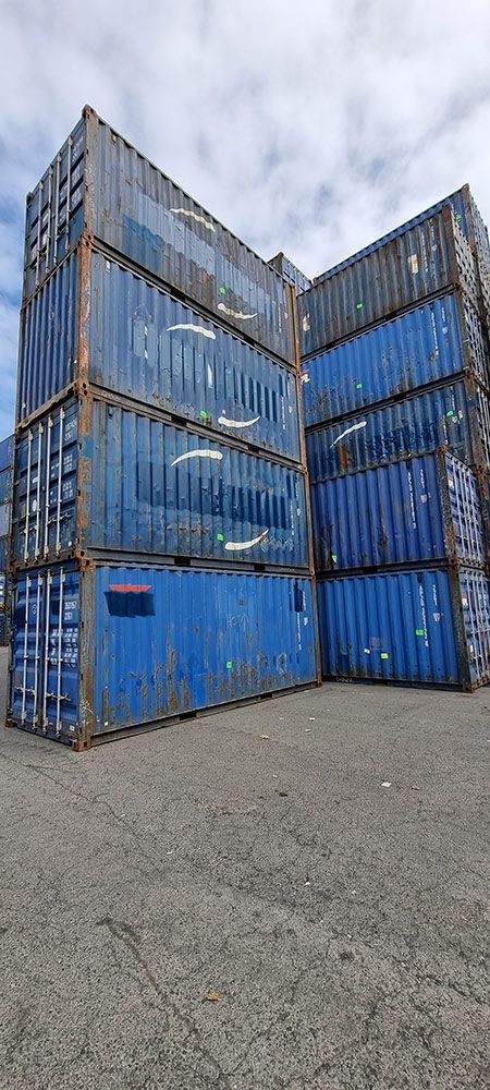 A Bunch Of Blue Shipping Containers Are Stacked On Top Of Each Other — Oz Shipping Containers in Coffs Harbour, NSW