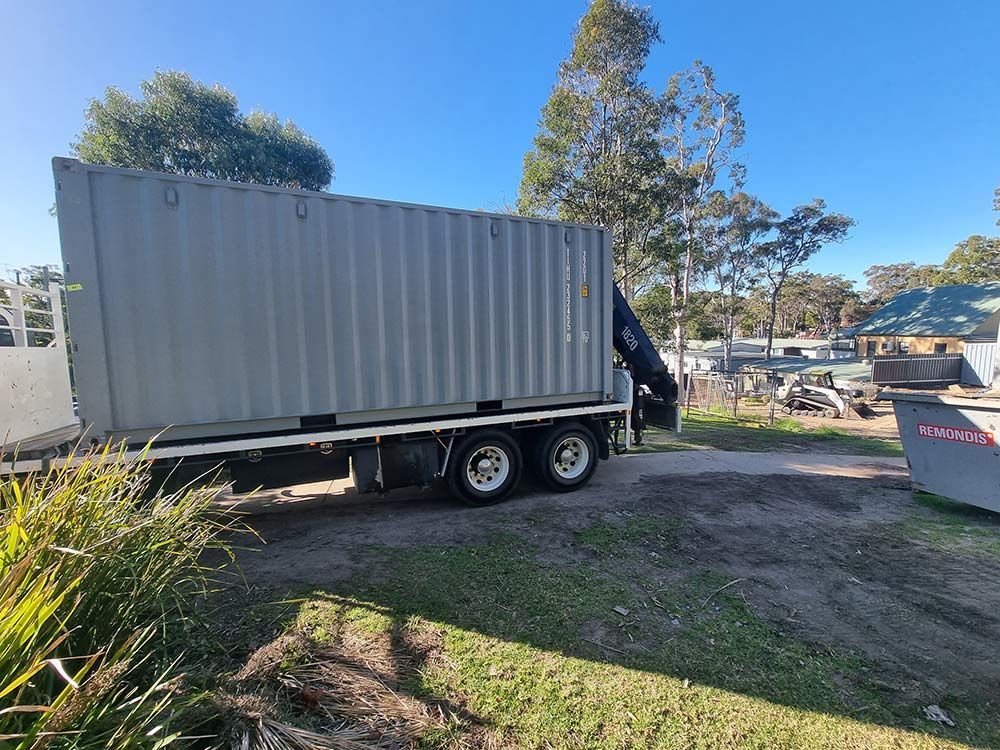 A Large Shipping Container Is Sitting On Top Of A Truck — Oz Shipping Containers in Gympie, QLD