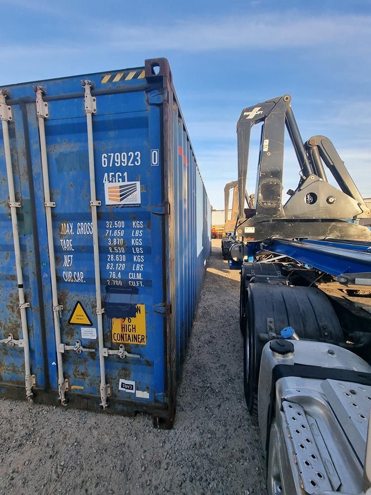 A Blue Shipping Container Is Parked Next To A Truck — Oz Shipping Containers in Teralba, NSW