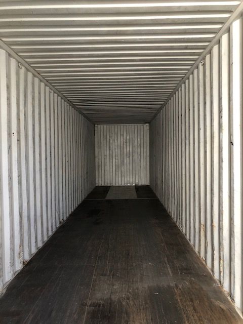 An Empty Shipping Container With A Wooden Floor And White Walls — Oz Shipping Containers in Teralba, NSW