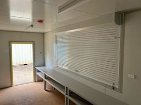 An Empty Container Room With A Table And A Window — Oz Shipping Containers in Teralba, NSW