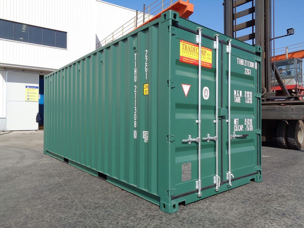 A Green Shipping Container Is Parked In Front Of A Building — Oz Shipping Containers in Teralba, NSW