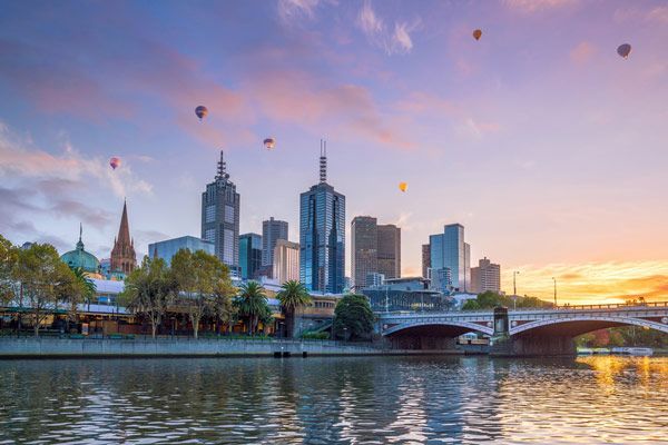 A Bridge Over A River With A City Skyline In The Background At Sunset — Oz Shipping Containers in Melbourne, VIC