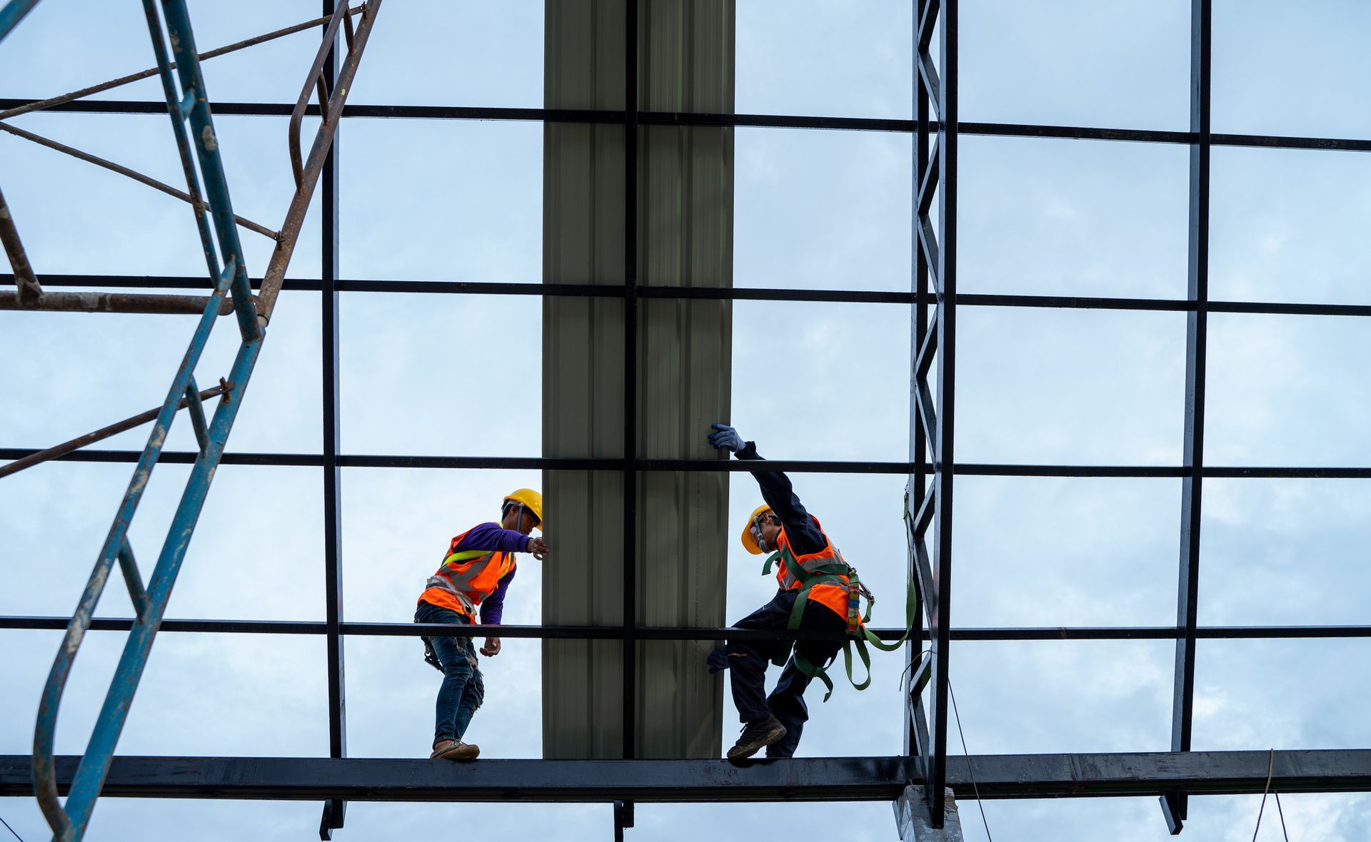 A couple of construction workers are working on a building.