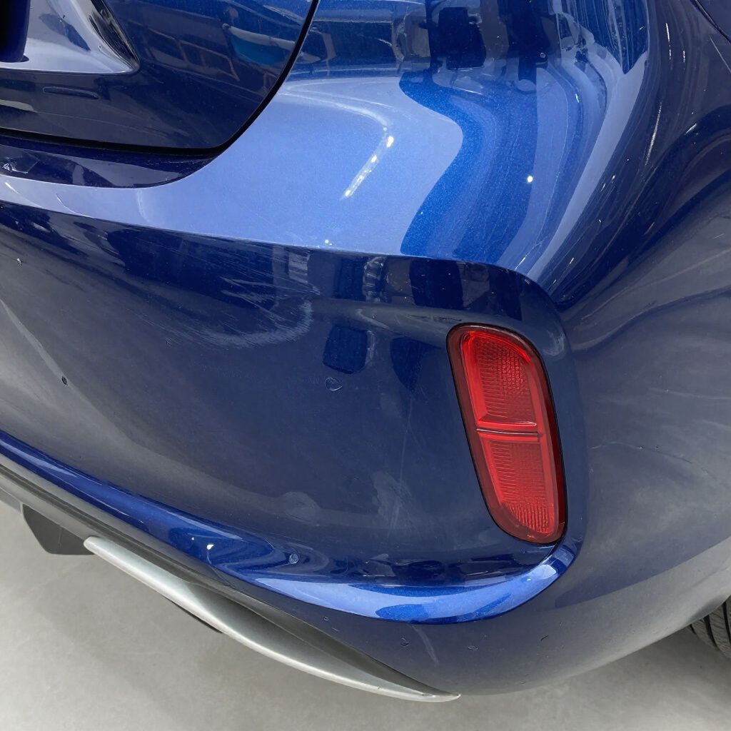 Close-up of a blue car’s rear bumper and red reflector near the lower edge