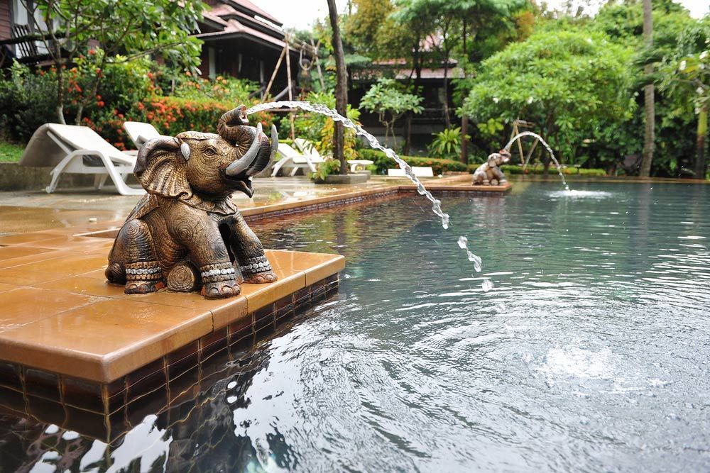 A Statue of an Elephant is Spraying Water Into a Swimming Pool — Taree Pool Supplies in Taree, NSW