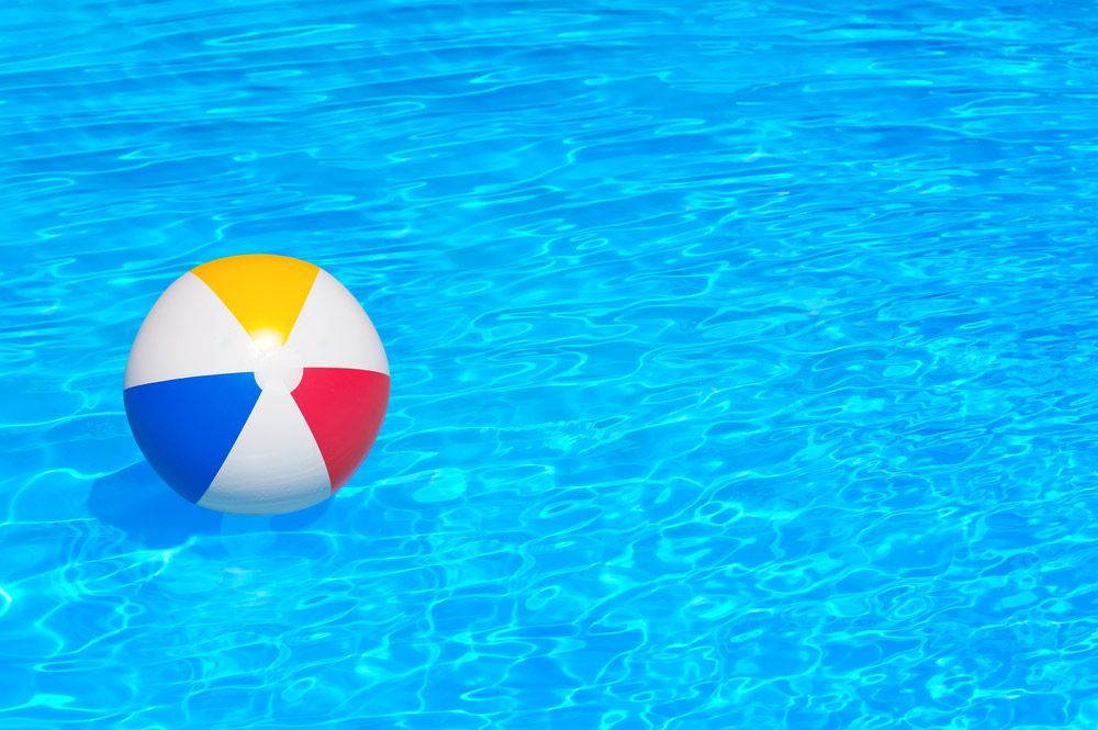 A Colorful Beach Ball is Floating in a Swimming Pool — Taree Pool Supplies in Forster, NSW