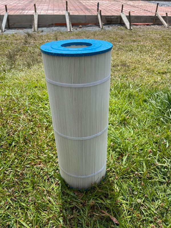 A Pool Filter is Sitting on Top of a Lush Green Field — Taree Pool Supplies in Taree, NSW