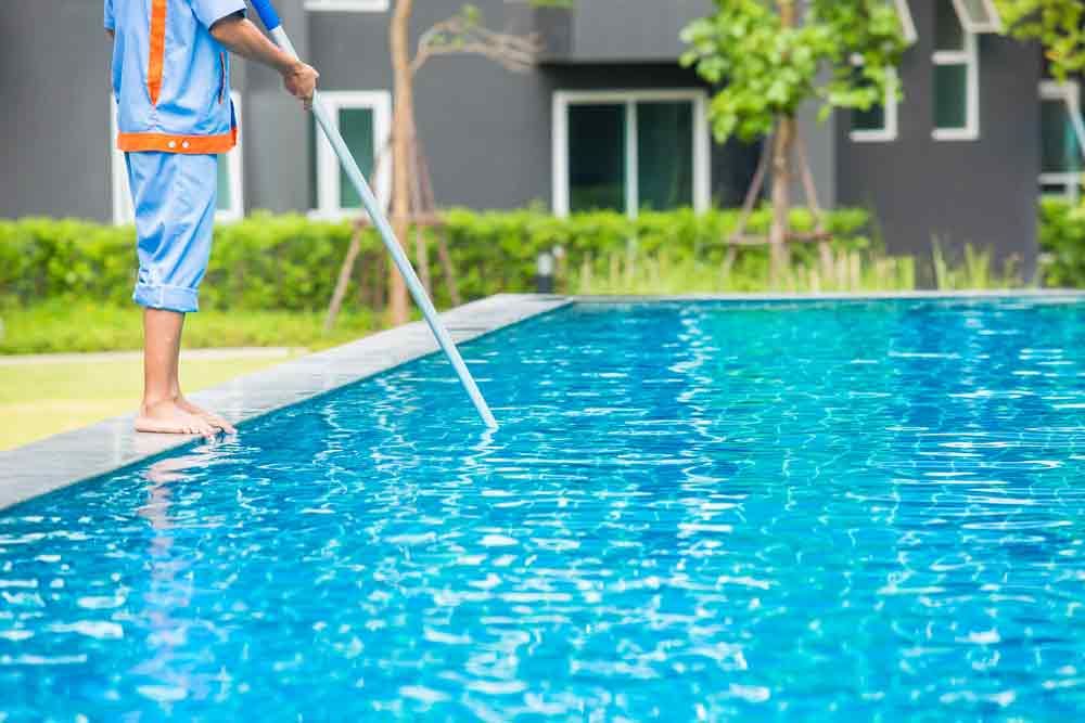 Man Cleaning the Swimming Pool — Taree Pool Supplies in Taree, NSW