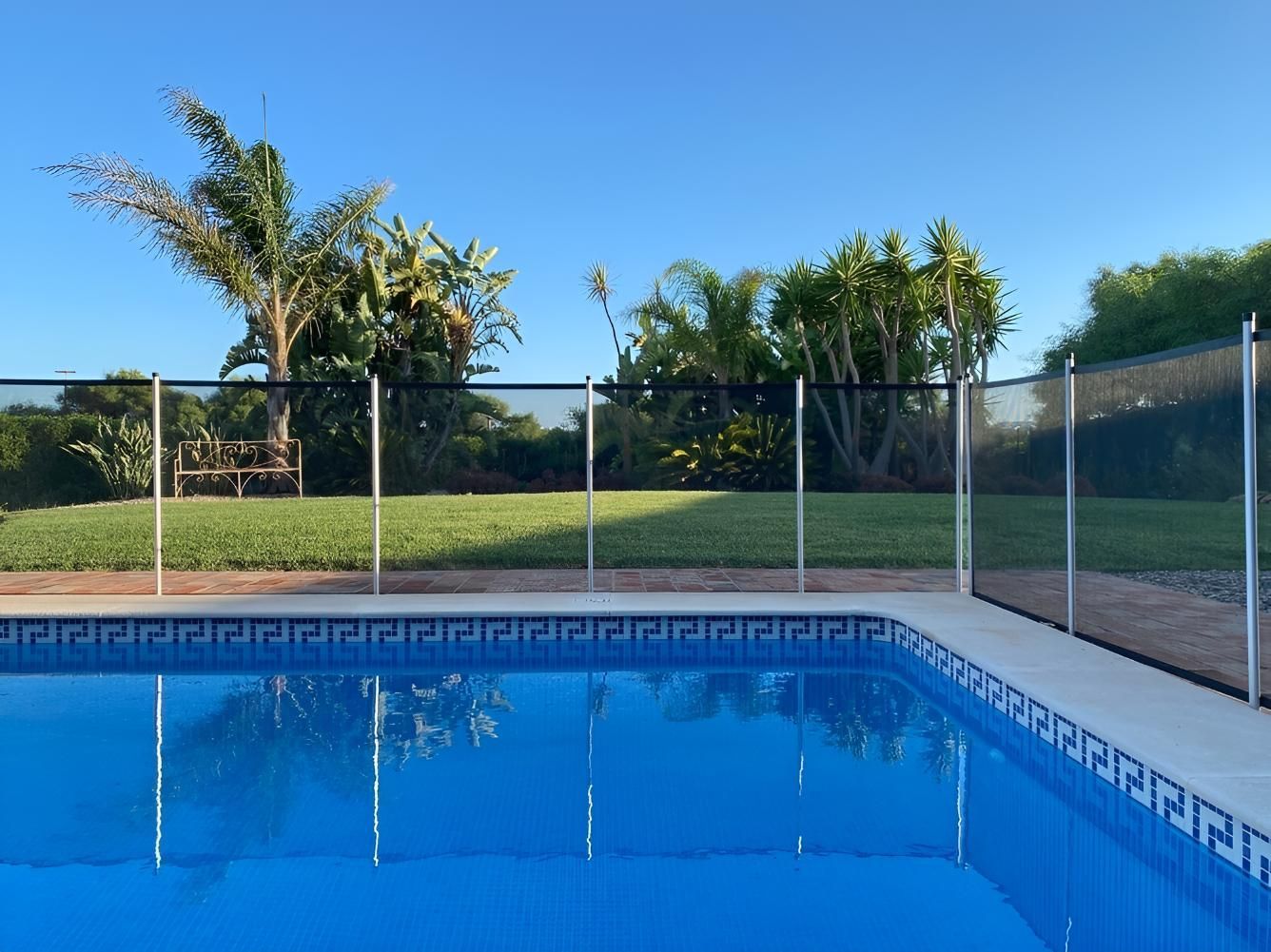 A Large Swimming Pool With a Fence Around It — Taree Pool Supplies in Taree, NSW