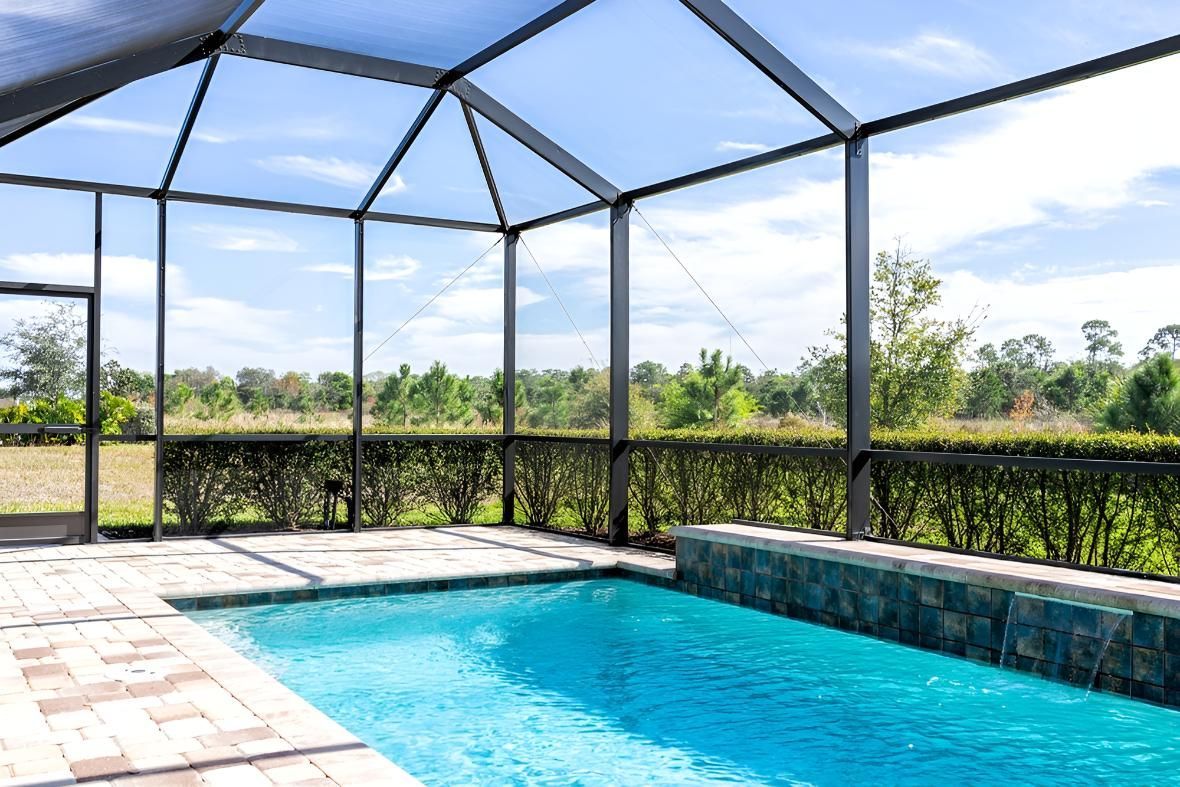 A Large Swimming Pool is Surrounded by a Screened in Area — Taree Pool Supplies in Taree, NSW
