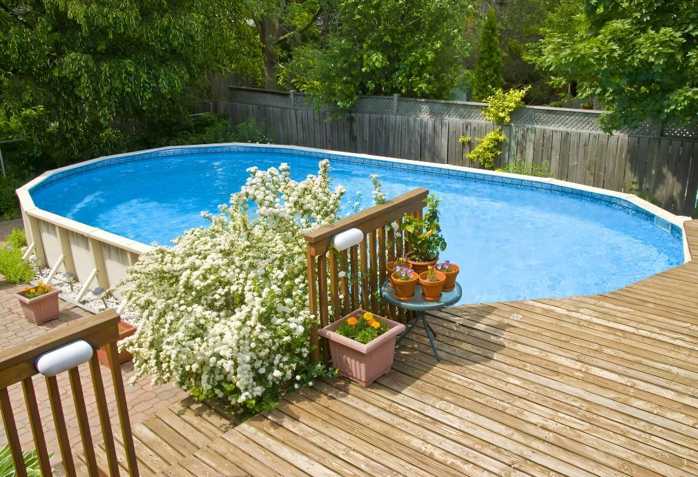 A Large Swimming Pool is Sitting on Top of a Wooden Deck — Taree Pool Supplies in Taree, NSW