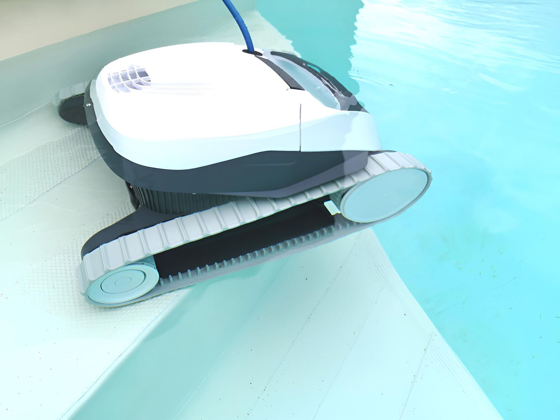 A Robotic Vacuum Cleaner is Sitting on the Edge of a Swimming Pool — Taree Pool Supplies in Taree, NSW