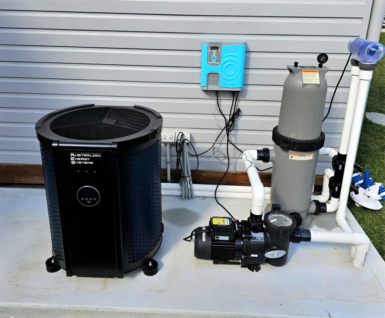 A Pool Pump and Heater Are Sitting on the Side of a House — Taree Pool Supplies in Taree, NSW