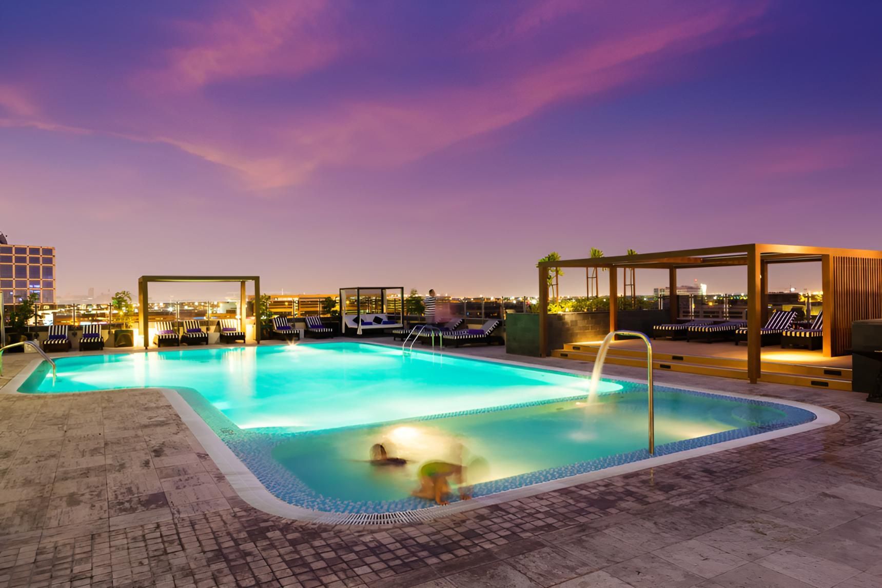 A Large Swimming Pool is Lit Up at Night — Taree Pool Supplies in Forster, NSW