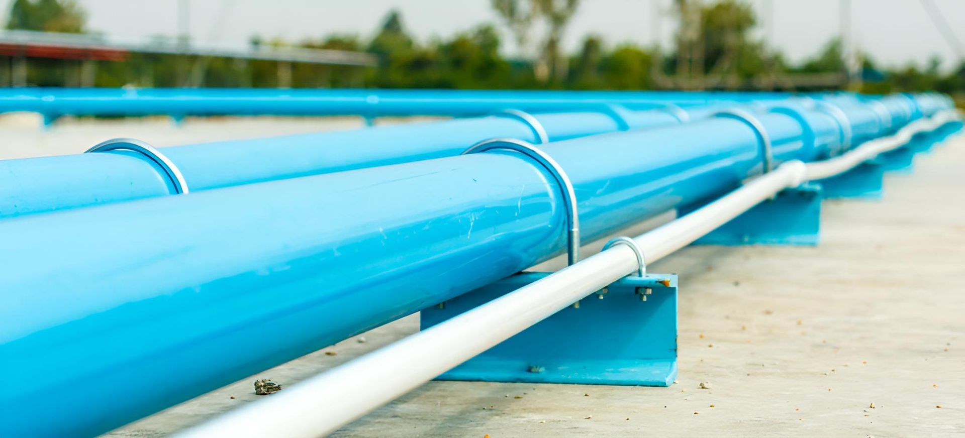 A Row of Blue Pipes Sitting on Top of a Concrete Surface — Taree Pool Supplies in Taree, NSW