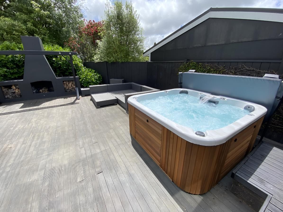 A Hot Tub is Sitting on Top of a Concrete Deck — Taree Pool Supplies in Taree, NSW