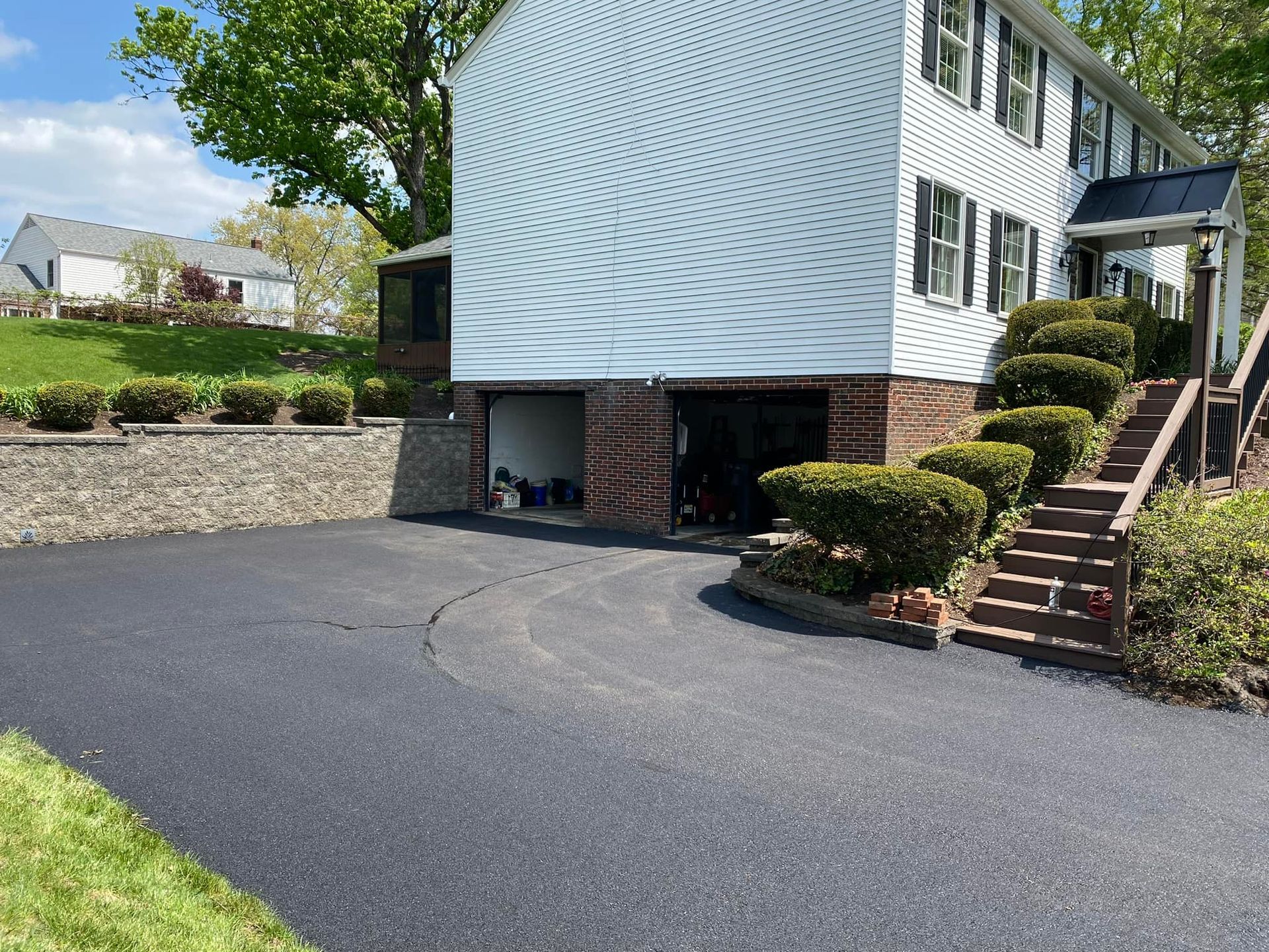 A large white house with a garage and stairs leading up to it.