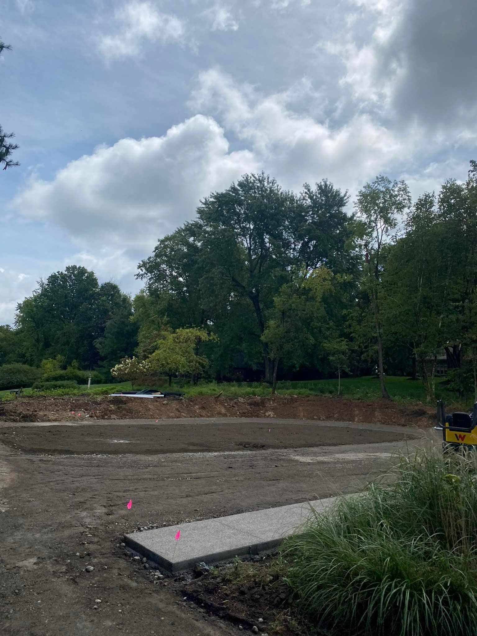 A construction site with a lot of dirt and trees in the background.