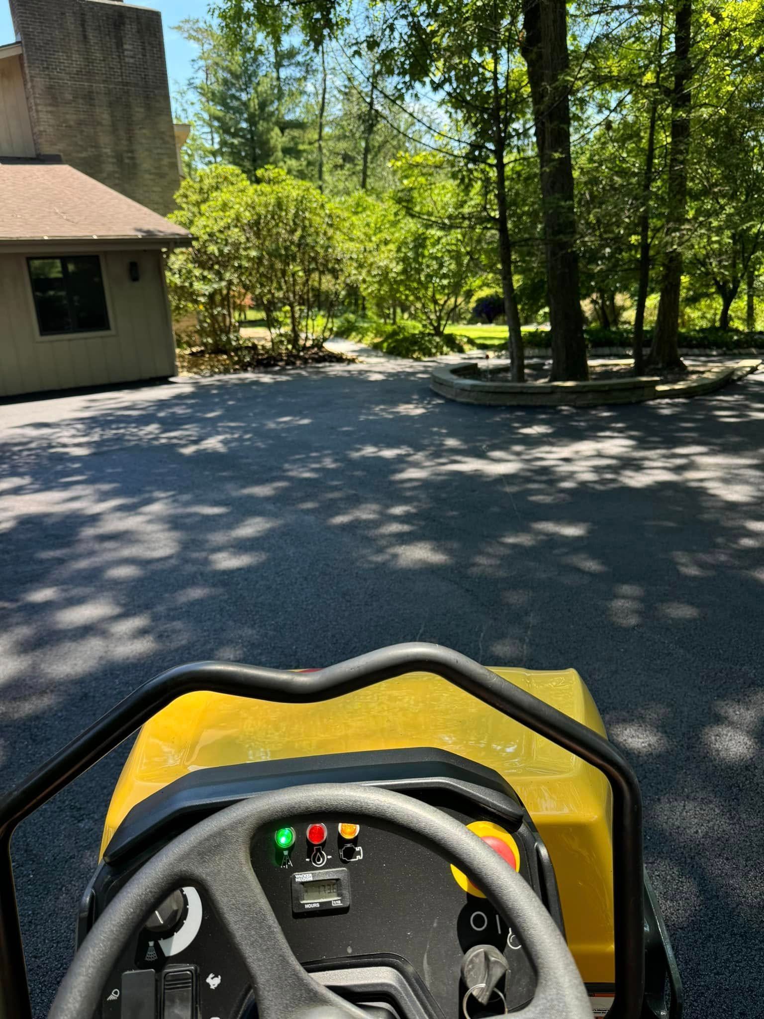 A person is driving a yellow golf cart down a road.