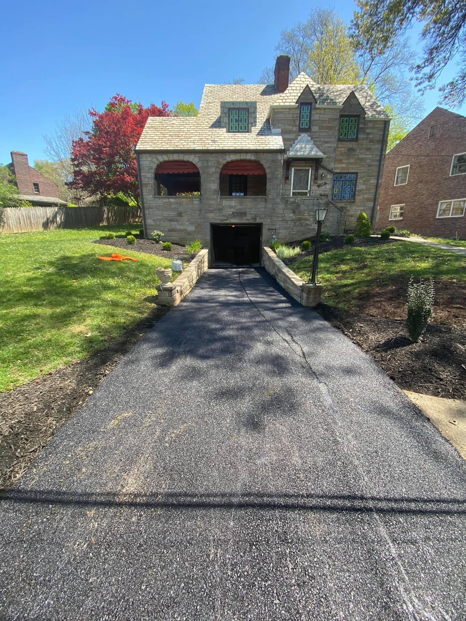 A large stone house with a driveway leading to it.