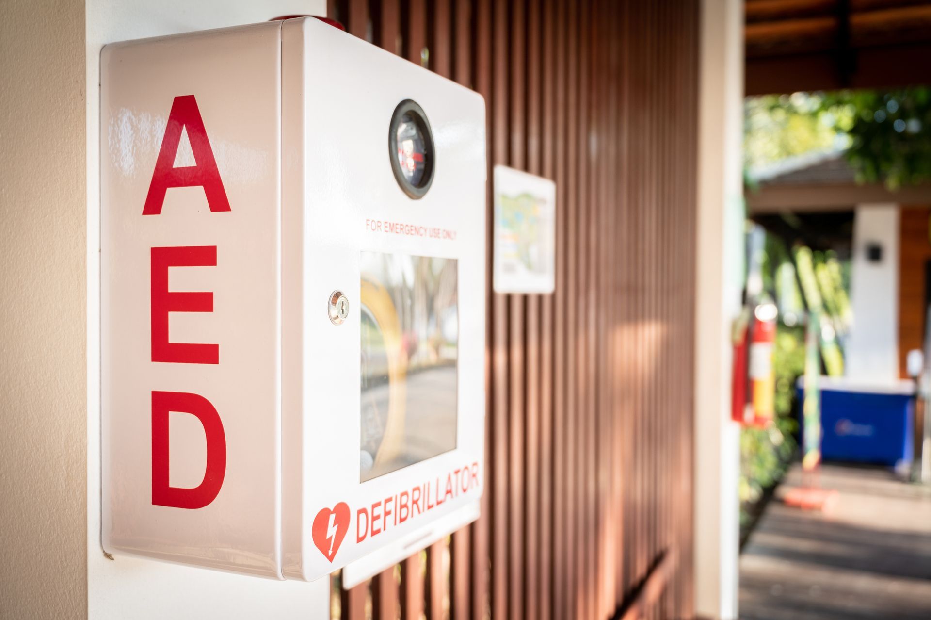 A box with the word AED on it is on the side of a building.