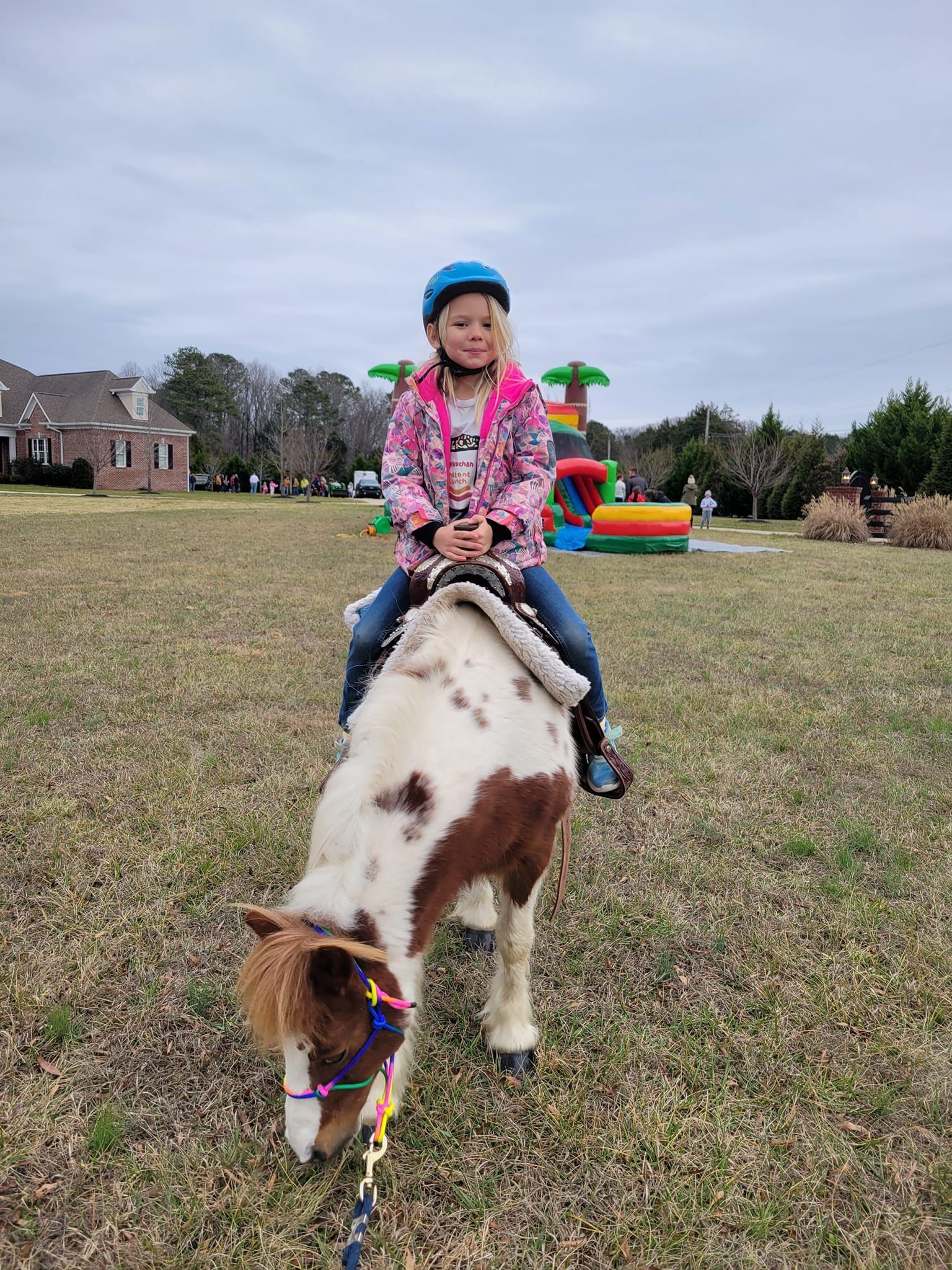 A little girl is riding a pony in a field.