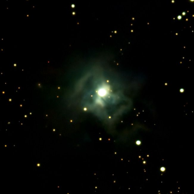 Green nebula glowing amid a star field in deep black space