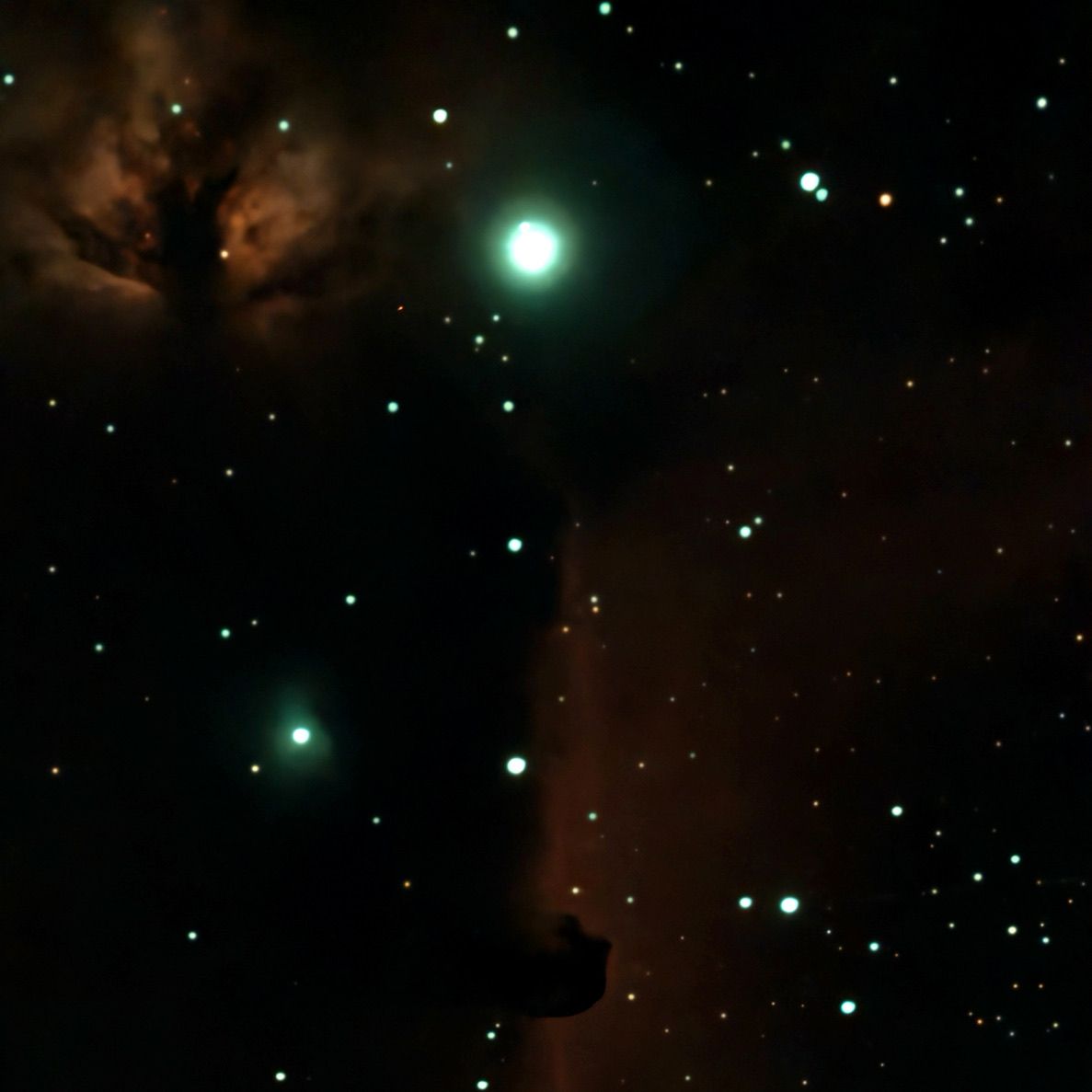 Bright star field with a glowing green star and reddish nebula clouds in a dark sky