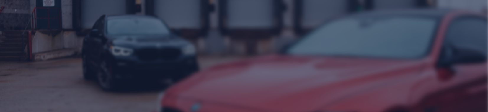 Red car and black car parked with blurry background | Firo's Autohaus
