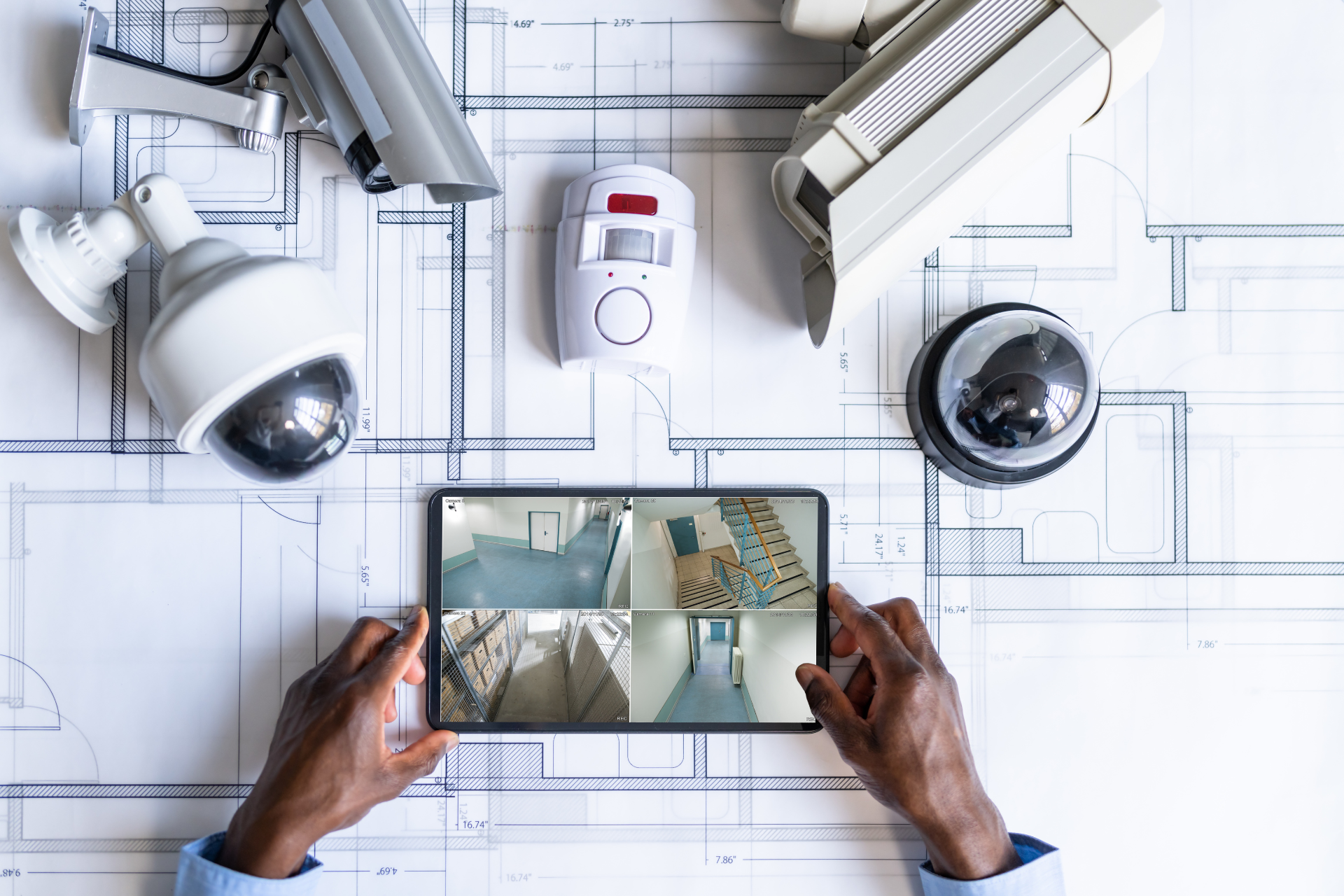 A person is holding a tablet with a security camera on it.