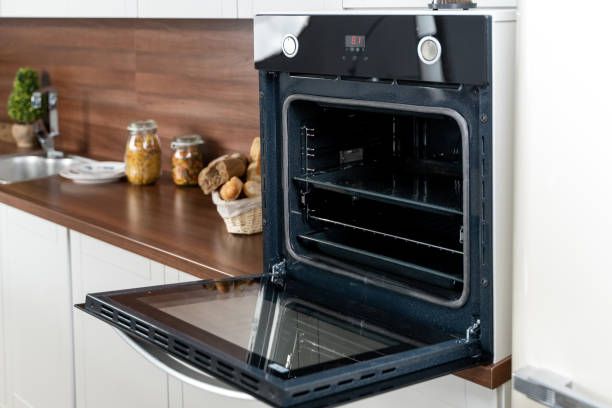 An oven with its door open in a kitchen, showing the interior.
