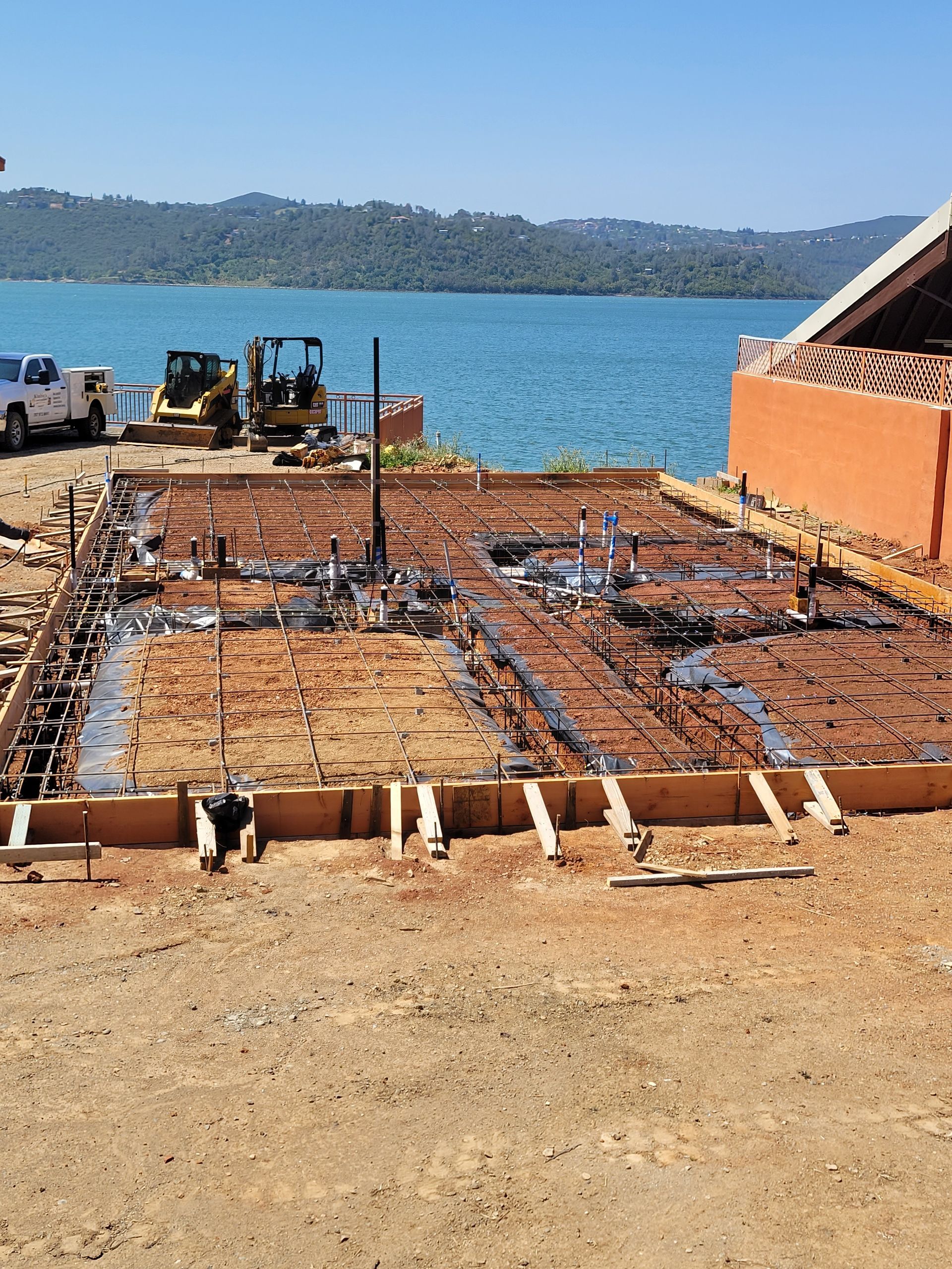 Construction workers building a concrete block wall on a sunny day.
