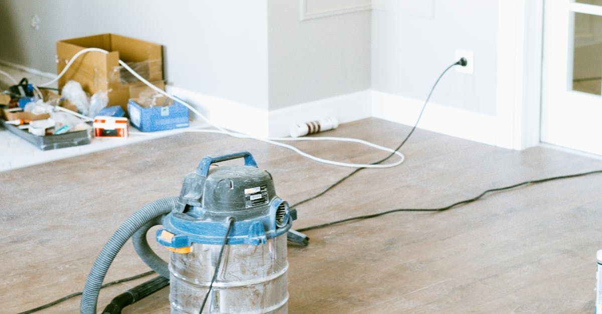 A vacuum cleaner is sitting on a wooden floor in a room.
