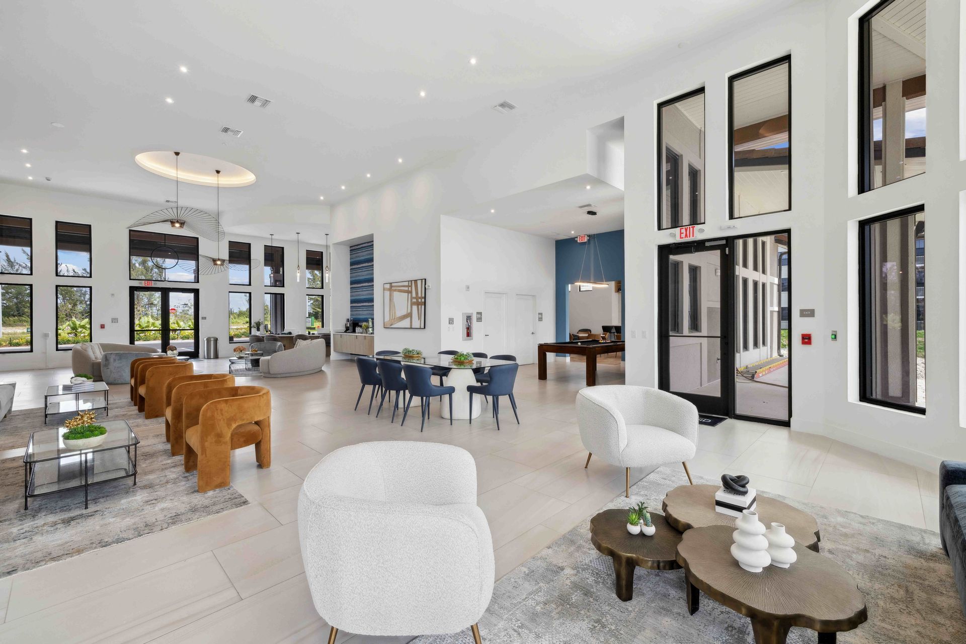 Spacious, bright lobby with seating areas, a dining table, and large windows.