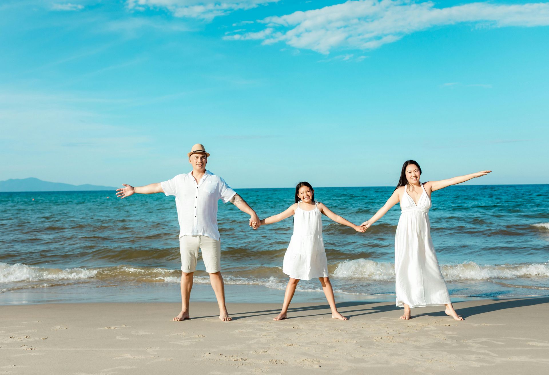 Happy family in white walking on tropical beach, family cruise vacation travel planning