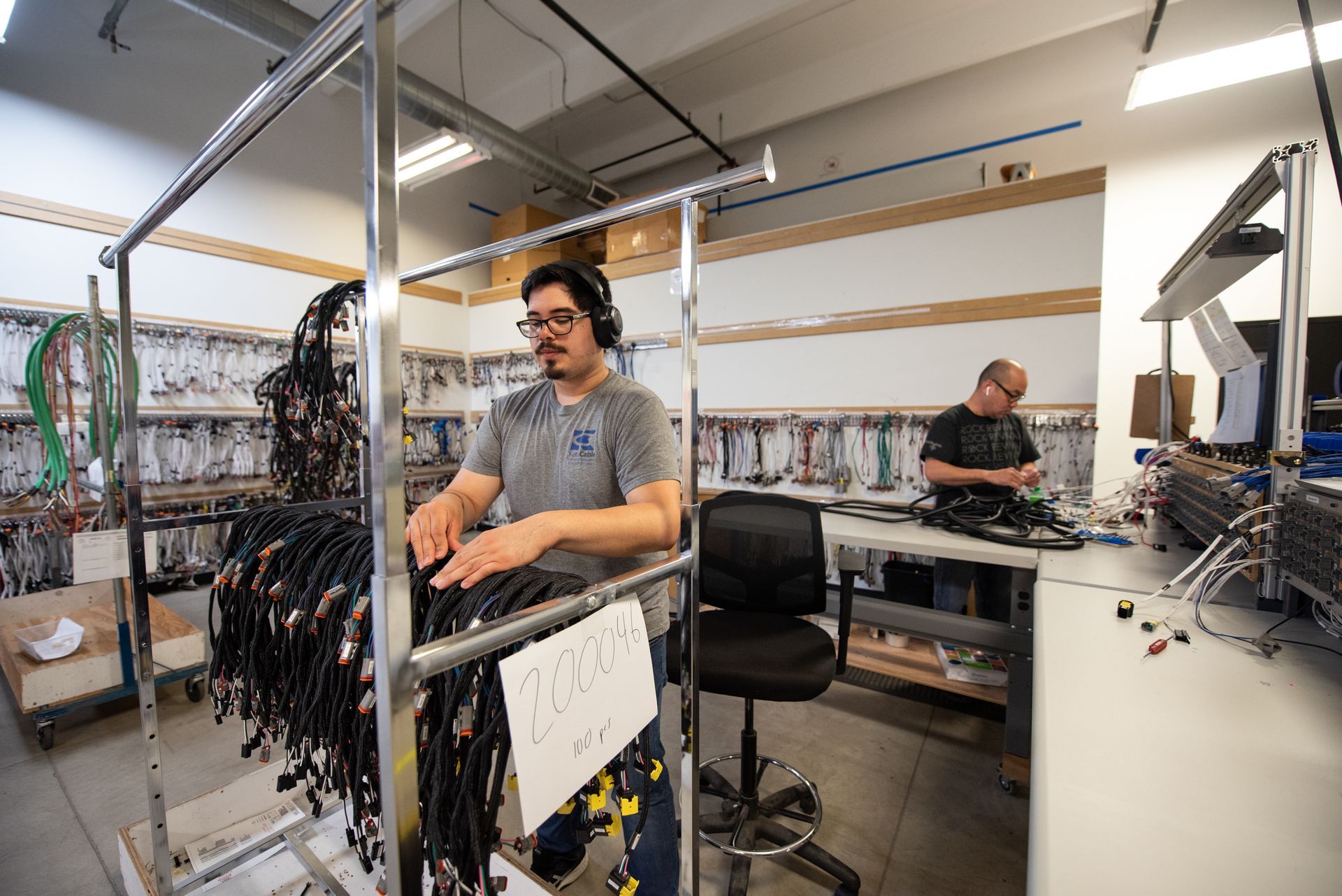 A man wearing headphones is working in a factory.
