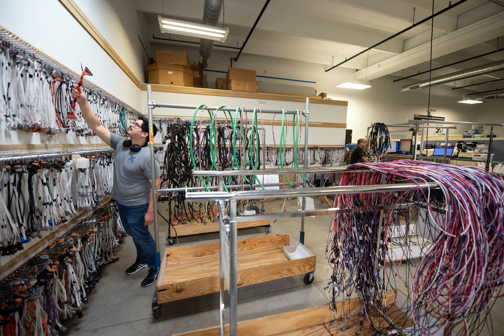A male Kato Cable technician inspecting wires and cable assemblies.