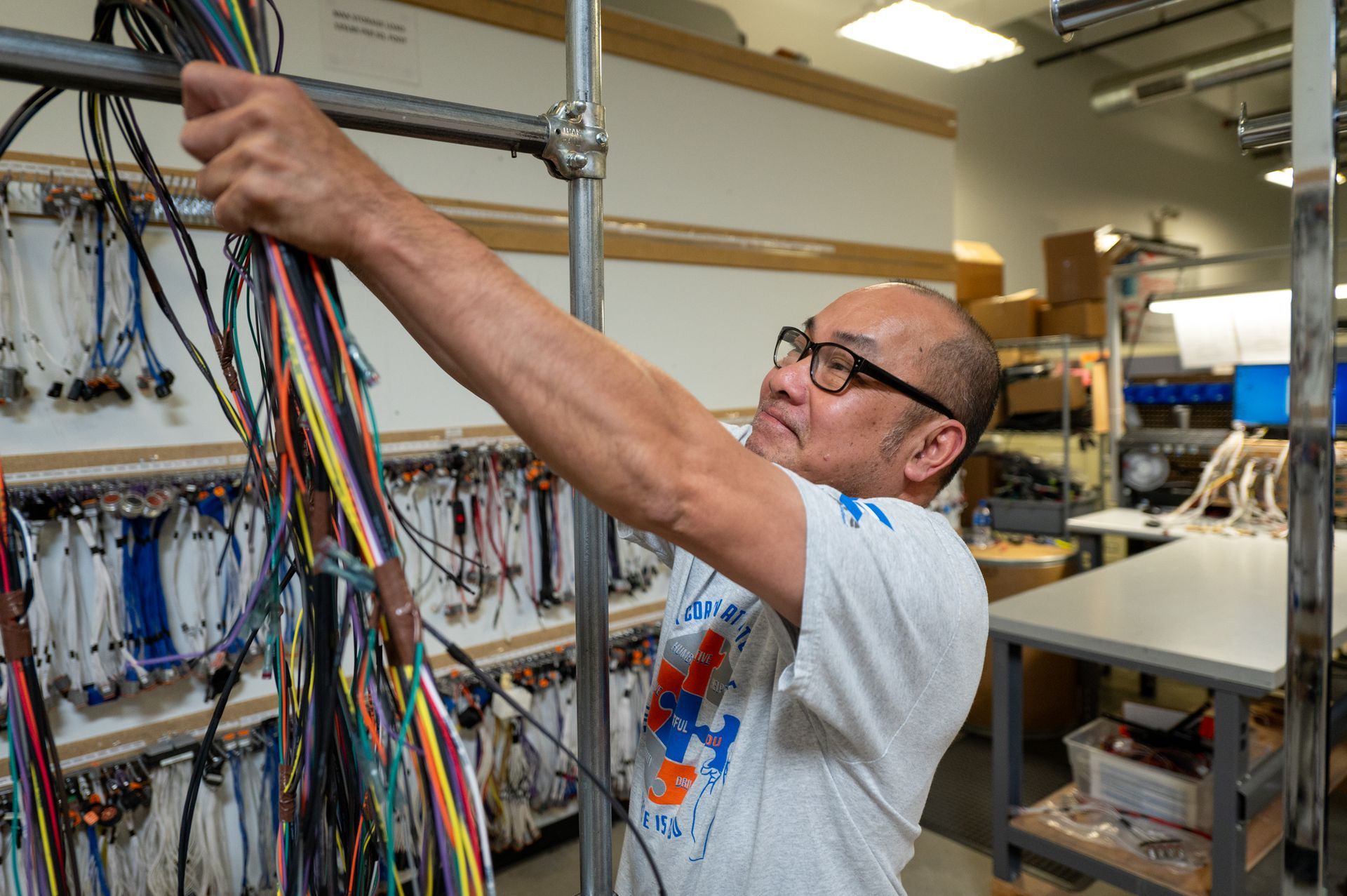 A male Kato Cable technician working on a cable assembly.