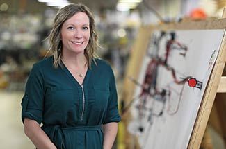 Kato Cable Sales Manager Nikki Dills standing beside wiring schematic in production facility