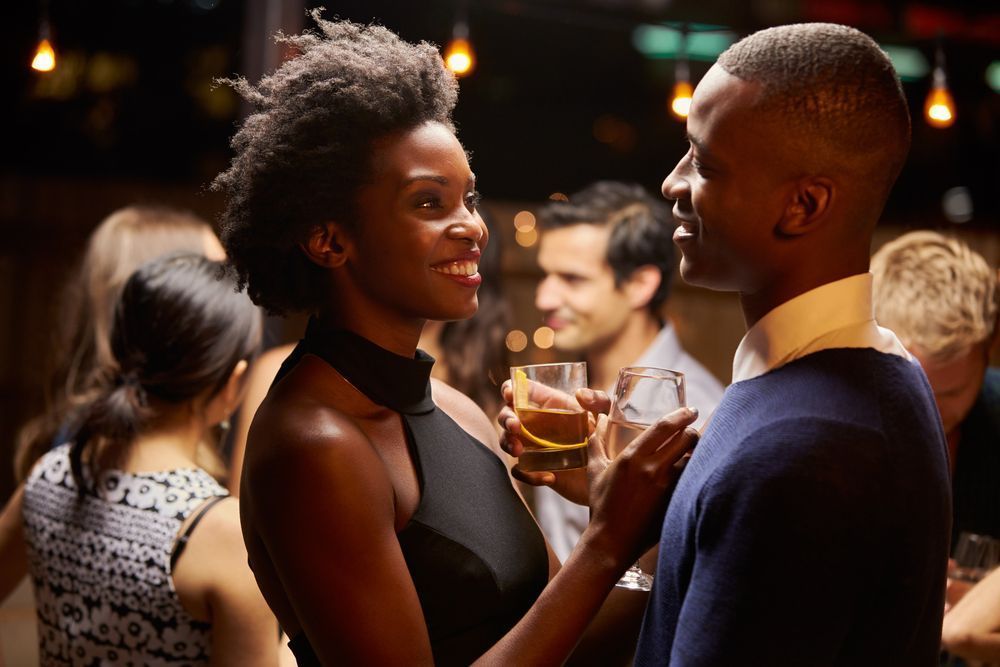 A man and a woman are standing next to each other at a party.