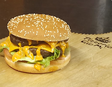 Cheeseburger con semi di sesamo, lattuga e formaggio fuso su un tagliere di legno