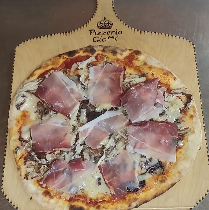 Pizza con prosciutto servita su un tagliere di legno