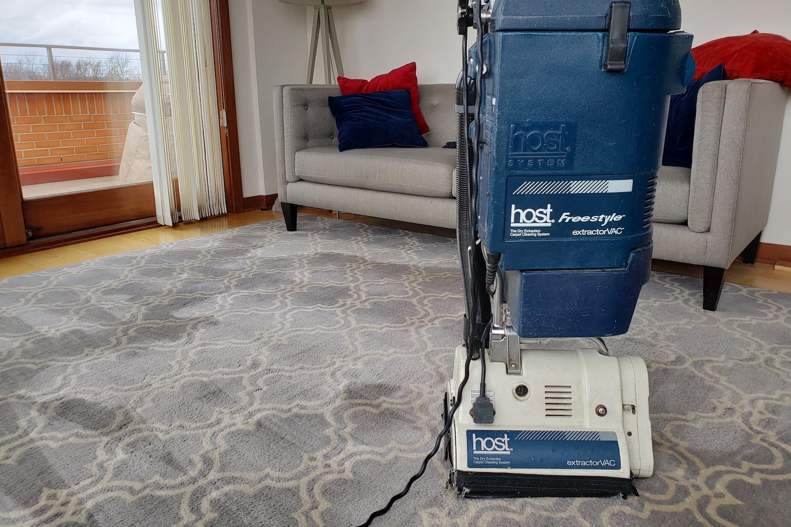 A vacuum cleaner is sitting on a rug in a living room.